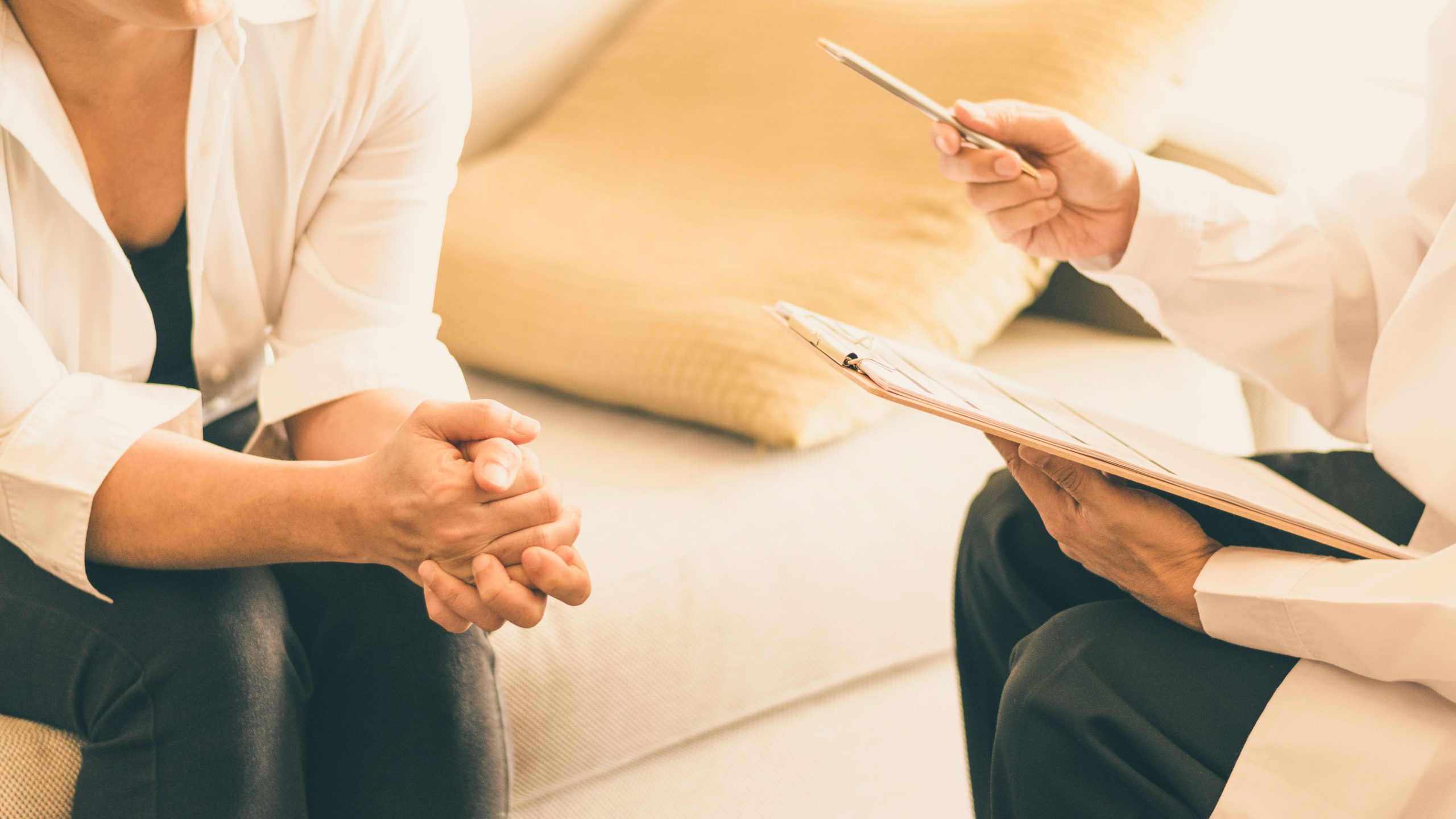 Two people site together on a couch during a counselling session.