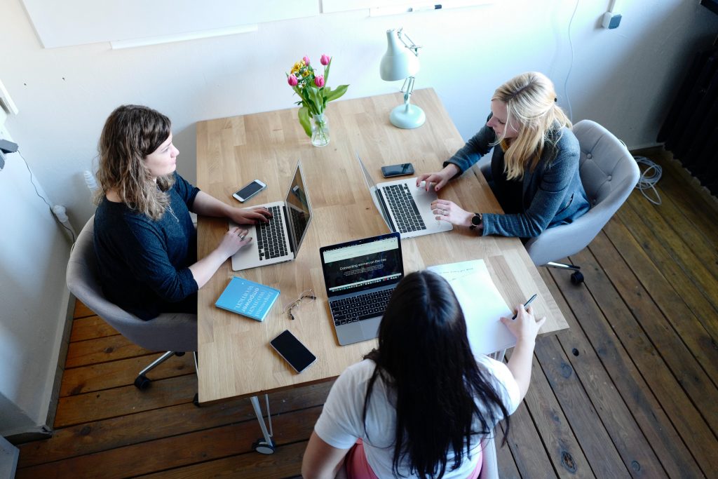 A group of people work together in a room on computers.