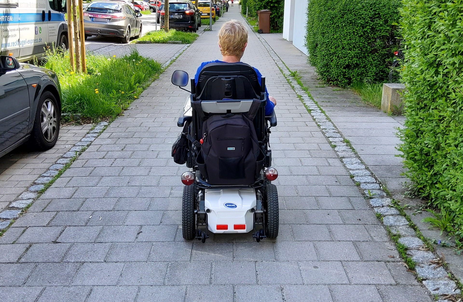 A women heads down the path in a wheelchair.