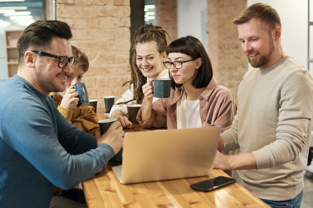 A group of people work together and drink coffee