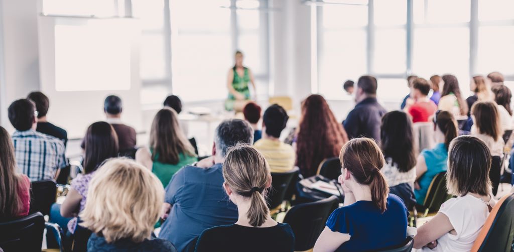 A group of people work together as they listen to a speaker.